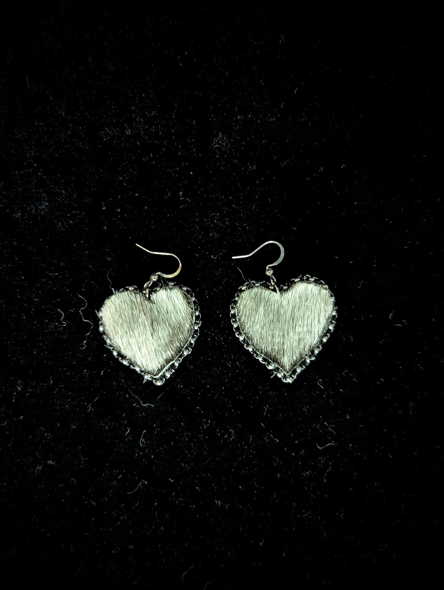 Heart-shaped earrings on a black background