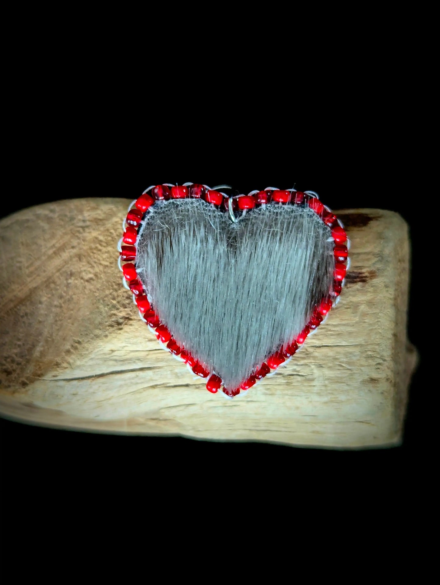 Heart-shaped object with red border on a wooden surface