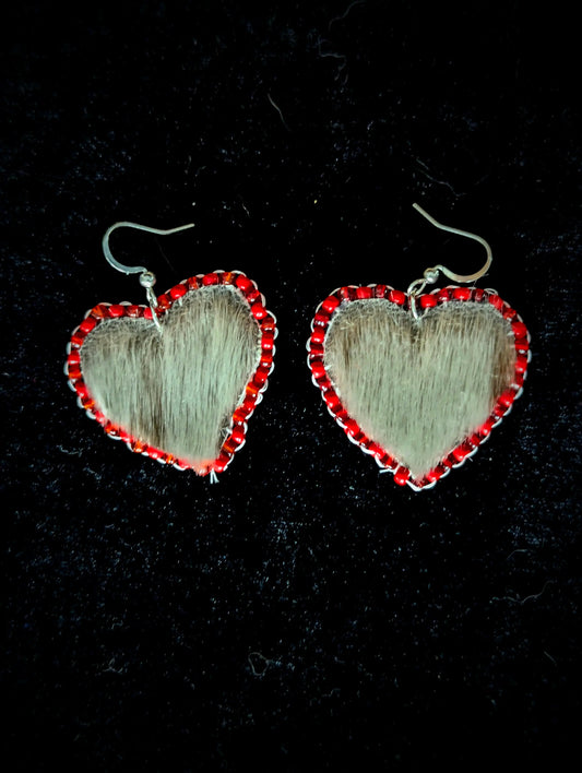 Heart-shaped earrings with red accents on a black background